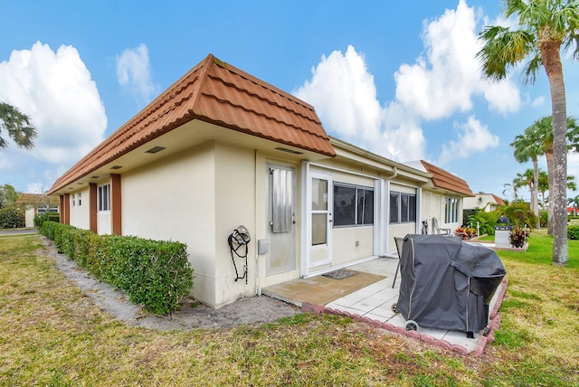 rear view of house with a patio area and a lawn