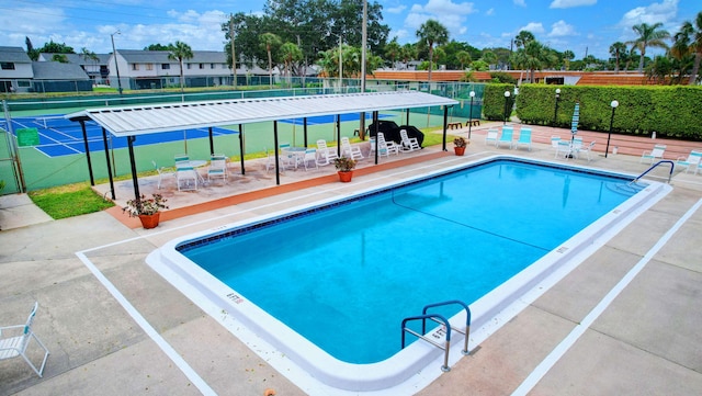 view of pool with tennis court