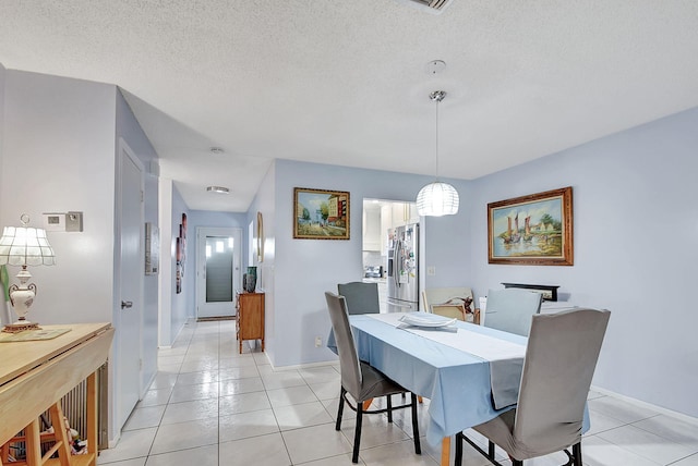 dining space with light tile patterned flooring and a textured ceiling