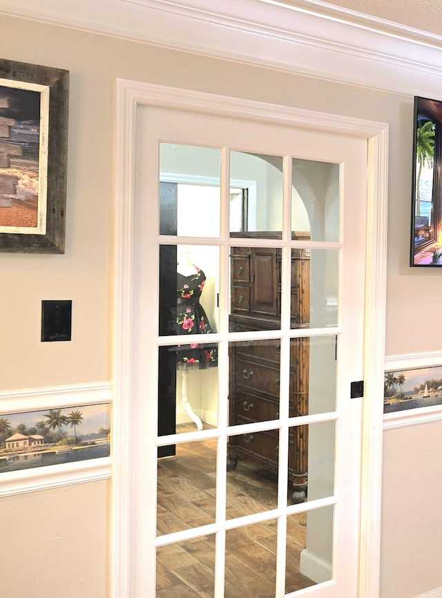 doorway featuring hardwood / wood-style floors and ornamental molding