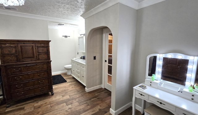 bathroom featuring vanity, a textured ceiling, crown molding, hardwood / wood-style floors, and toilet