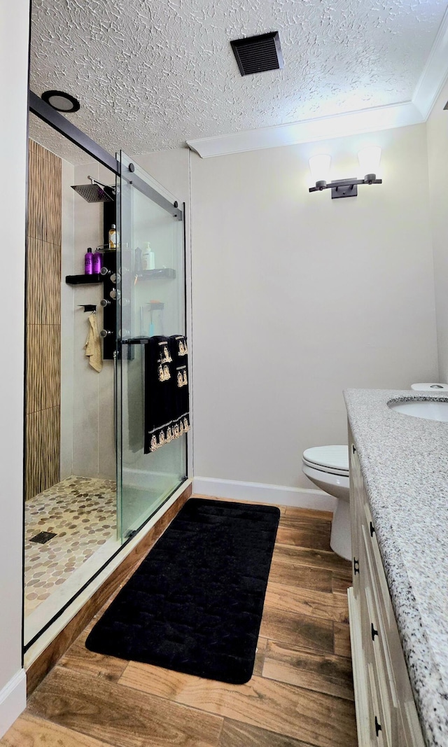 bathroom featuring vanity, crown molding, wood-type flooring, and a textured ceiling