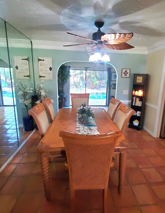 tiled dining space with a textured ceiling, plenty of natural light, ornamental molding, and ceiling fan