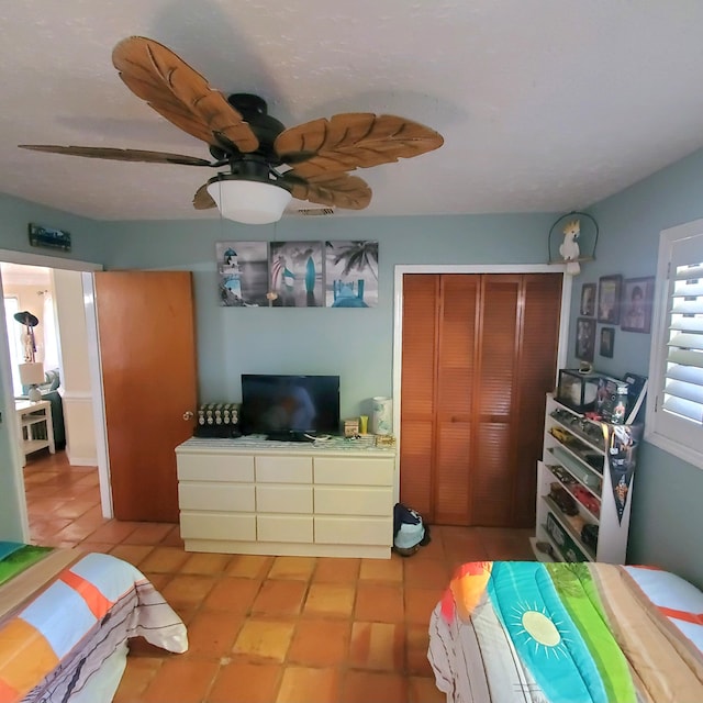 bedroom featuring light tile patterned floors, a closet, and ceiling fan