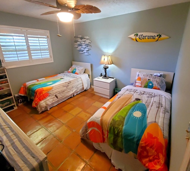 tiled bedroom featuring ceiling fan