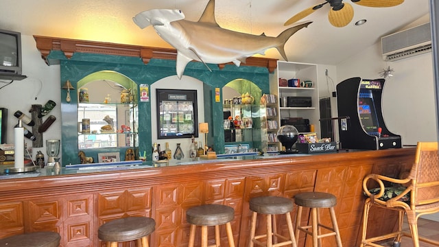 bar featuring a wall mounted AC, ceiling fan, and vaulted ceiling