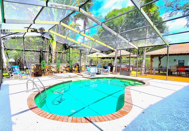 view of pool featuring a lanai, a patio area, and a hot tub