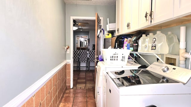 laundry room featuring cabinets, dark tile patterned floors, washer and clothes dryer, and ceiling fan