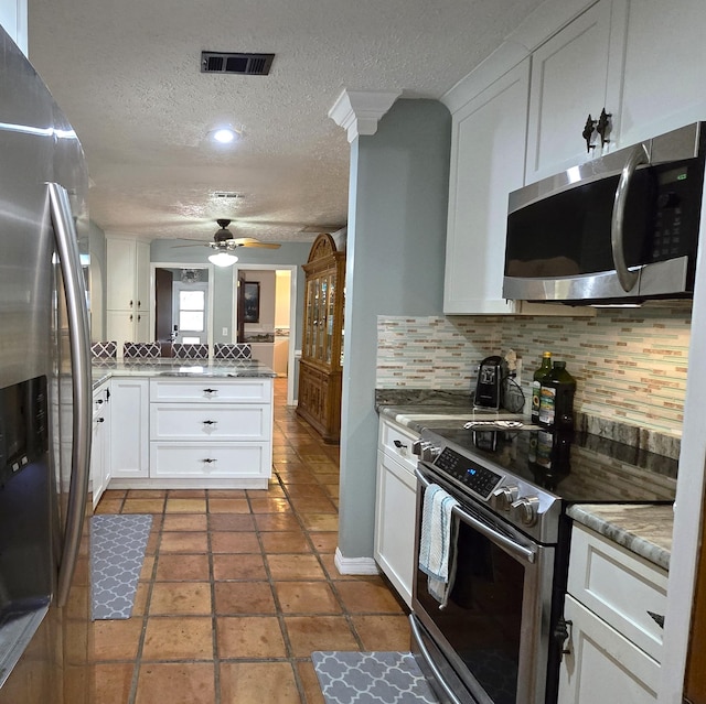 kitchen with ceiling fan, stainless steel appliances, tasteful backsplash, kitchen peninsula, and white cabinets