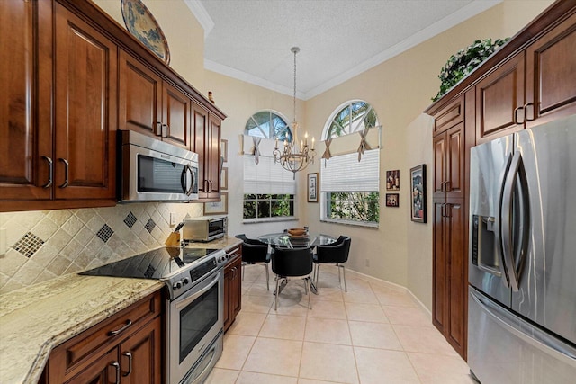 kitchen featuring tasteful backsplash, a notable chandelier, a toaster, light stone countertops, and appliances with stainless steel finishes