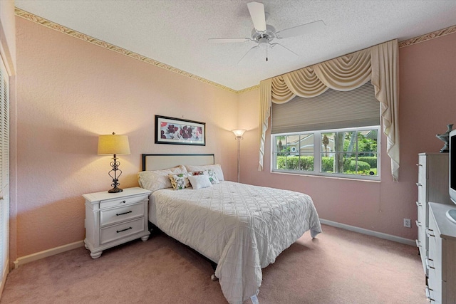 bedroom featuring light carpet, baseboards, and ceiling fan