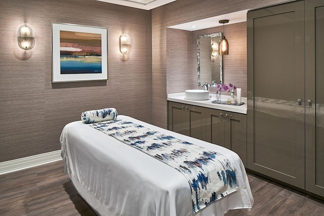 bedroom featuring dark wood-style floors, baseboards, and a sink