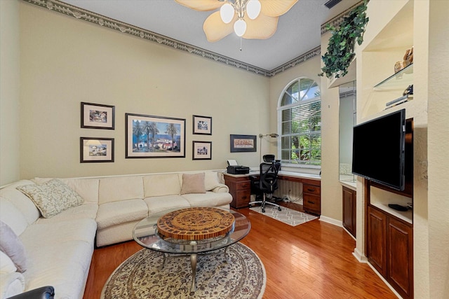 living room with light wood finished floors and a ceiling fan