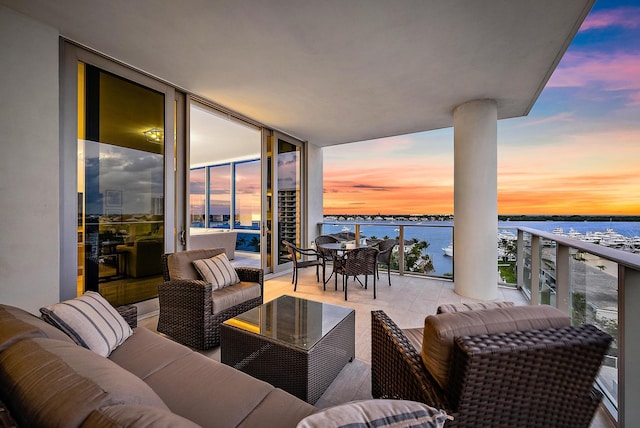 balcony at dusk with a water view and an outdoor hangout area