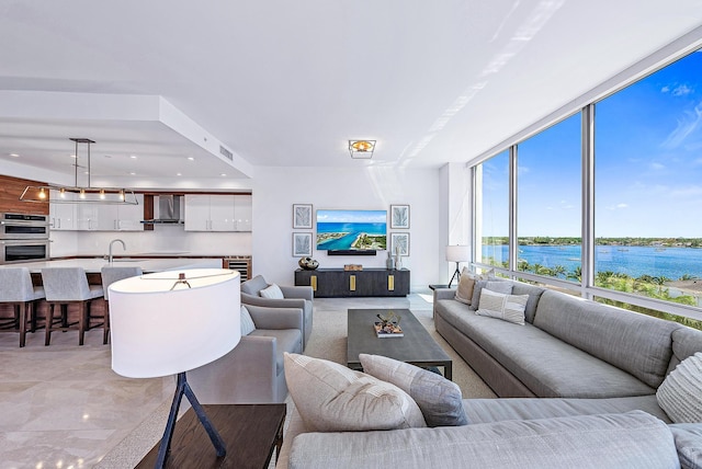 living room with a wall of windows, wine cooler, and sink