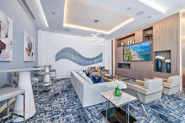 carpeted living room with a tray ceiling