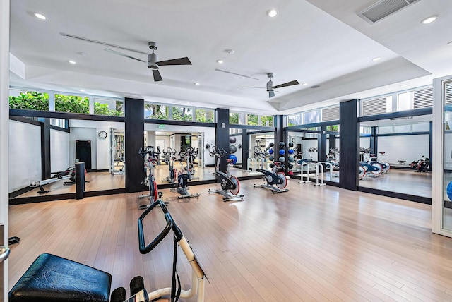 gym with ceiling fan and light hardwood / wood-style flooring