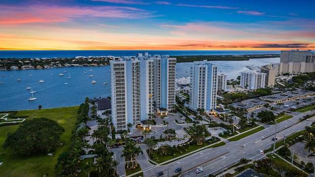 aerial view at dusk featuring a water view