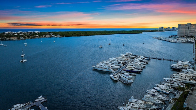 aerial view at dusk featuring a water view