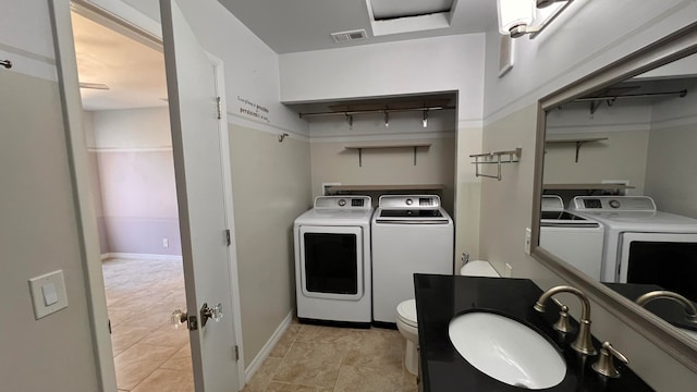 laundry area featuring sink, separate washer and dryer, and light tile patterned floors