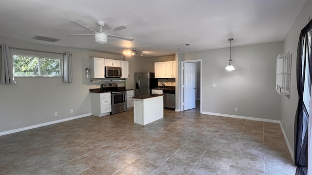 kitchen with hanging light fixtures, ceiling fan, white cabinetry, sink, and stainless steel appliances