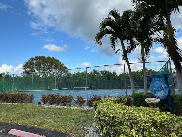 view of tennis court with a yard