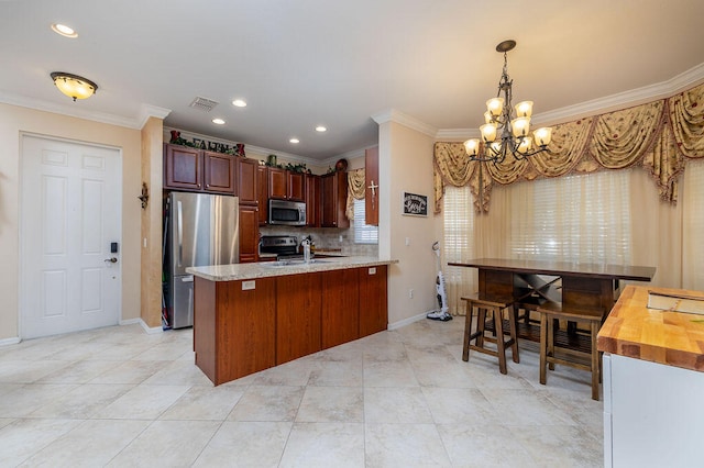 kitchen featuring decorative light fixtures, light tile flooring, stainless steel appliances, and crown molding