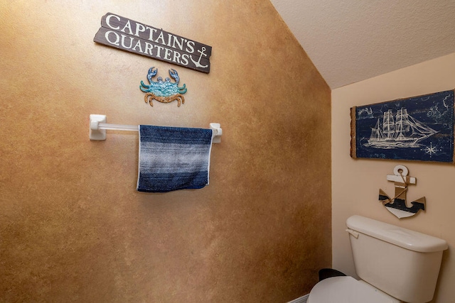 bathroom with vaulted ceiling, toilet, and a textured ceiling