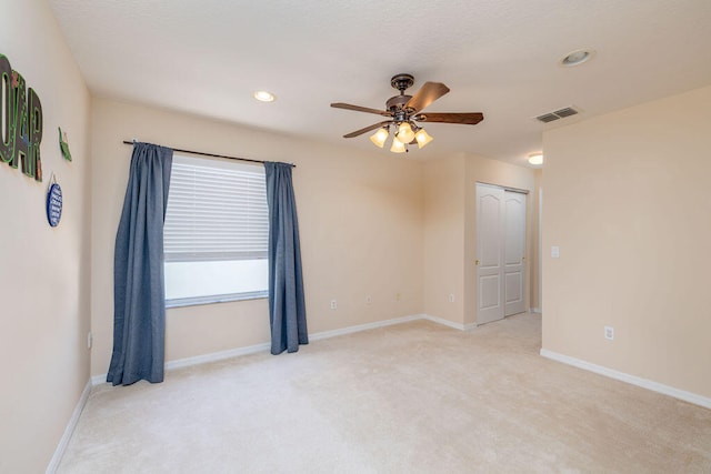 carpeted spare room with ceiling fan