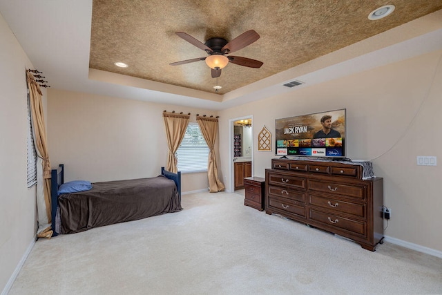 carpeted bedroom featuring a textured ceiling, a raised ceiling, and ceiling fan