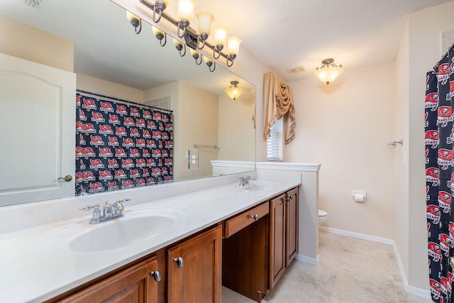 bathroom featuring tile flooring, vanity with extensive cabinet space, toilet, and double sink