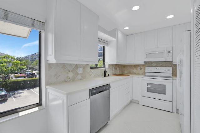 kitchen with light tile floors, sink, white appliances, tasteful backsplash, and white cabinetry