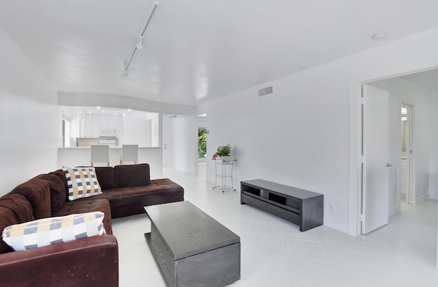 living room featuring light tile flooring and rail lighting