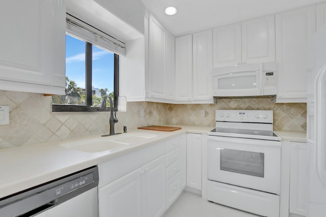 kitchen with white cabinetry, white appliances, and sink