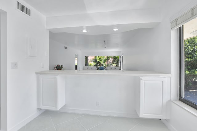 bar featuring light tile floors and white cabinetry