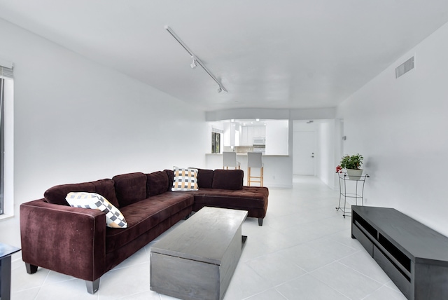 living room with rail lighting and light tile floors