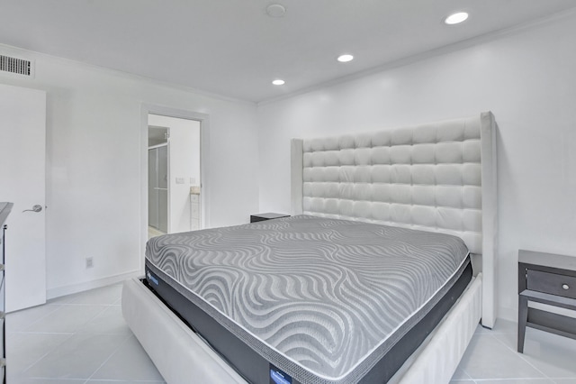 tiled bedroom featuring crown molding and ensuite bath