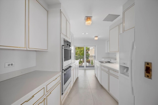 kitchen featuring white cabinets, light tile patterned flooring, and white fridge with ice dispenser