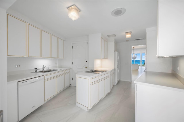 kitchen featuring white appliances, white cabinetry, and sink