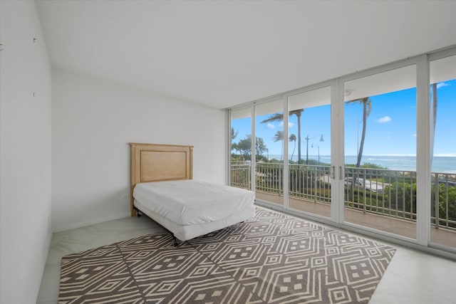 bedroom with access to exterior, multiple windows, and a water view