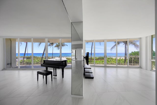 miscellaneous room featuring plenty of natural light, a water view, light tile patterned floors, and floor to ceiling windows