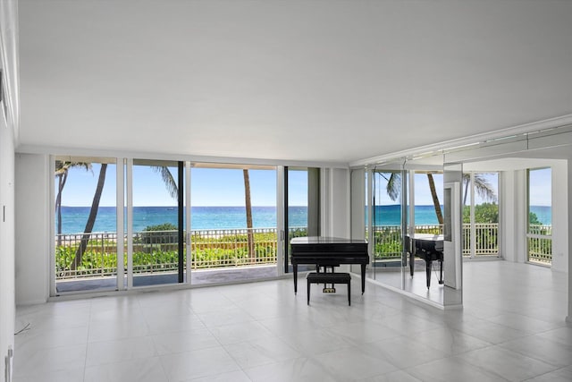 misc room with a water view, a healthy amount of sunlight, and expansive windows