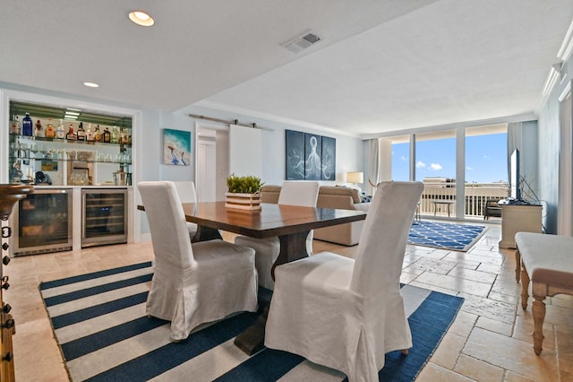 dining area featuring wine cooler, a wall of windows, crown molding, a barn door, and bar area