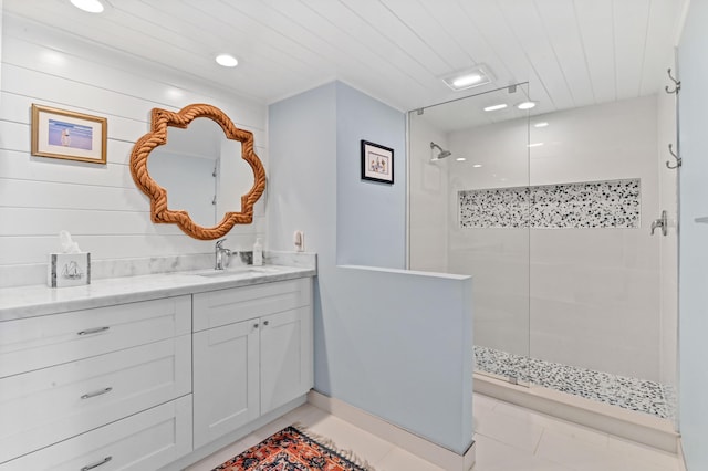 bathroom with vanity, tile patterned flooring, and tiled shower