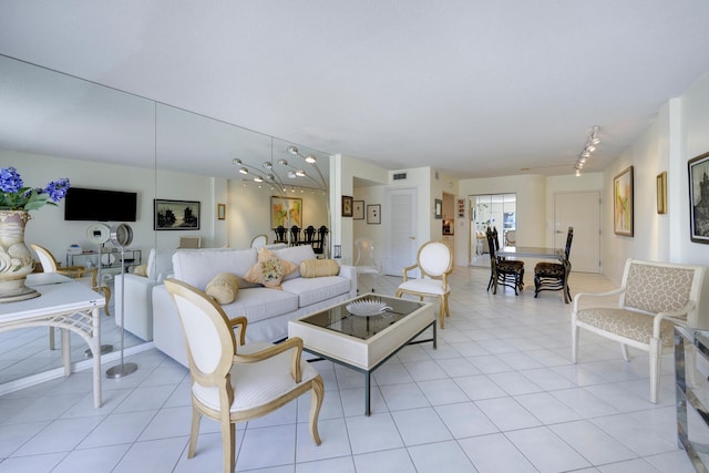 living room with track lighting, light tile floors, and an inviting chandelier