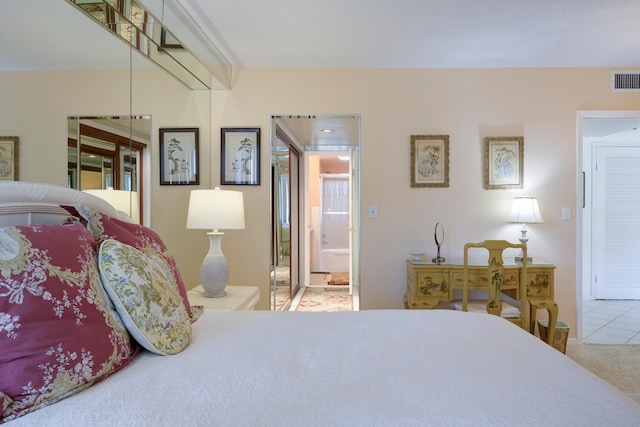 bedroom featuring light carpet and ensuite bathroom