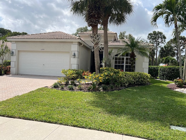 mediterranean / spanish-style home with a garage and a front yard