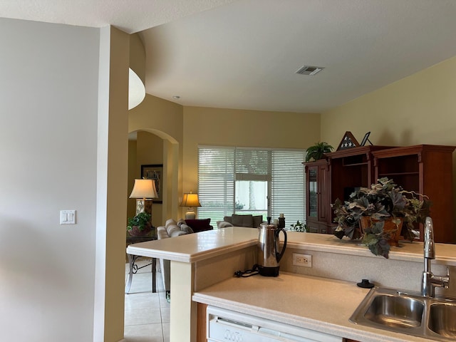 kitchen with dishwasher, sink, kitchen peninsula, and light tile patterned floors