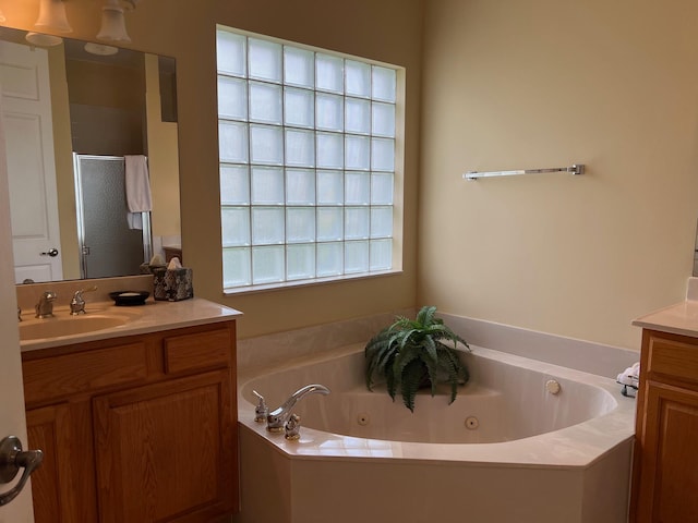 bathroom with vanity and shower with separate bathtub