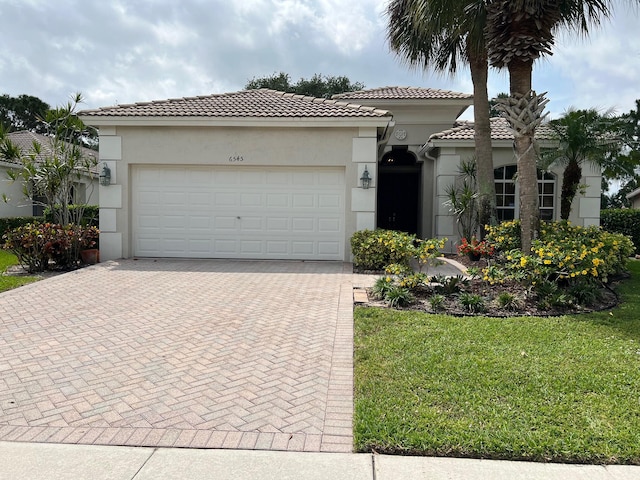 mediterranean / spanish house featuring a front lawn and a garage